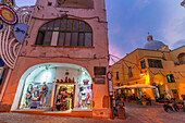 View of shops on Via Vittorio Emanuele in the fishing port at dusk, Procida, Phlegraean Islands, Gulf of Naples, Campania, Southern Italy, Italy, Europe