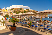 View of restaurants in Marina di Corricella and fortress in background, Procida, Phlegraean Islands, Gulf of Naples, Campania, Southern Italy, Italy, Europe