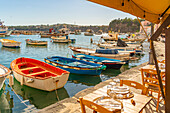 View of restaurant and boats in Marina di Corricella, Procida, Phlegraean Islands, Gulf of Naples, Campania, Southern Italy, Italy, Europe