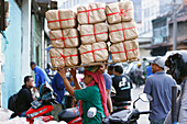 Daily worker at traditional food market, woman carrying heavy bags on her head, Surabaya, Java, Indonesia, South East Asia, Asia