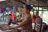 Woman using a mallet to fold batik fabric, Nyah Kiok batik house, craft production by seven women for over 30 years, Lasem, Java island, Indonesia, Southeast Asia, Asia