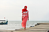 Young woman walking on a pontoon at Karangjahe Beach near Lasem, Java island, Indonesia, Southeast Asia, Asia