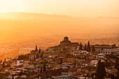 Dunstiger orange-roter Sonnenuntergang über Granada von San Miguel Alto aus gesehen über dem Albaicin alto und der Iglesia de San Cristobal. Granada,Andalusien,Spanien,Europa