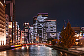 Night time cityscape with skyscrapers on Tosahori River and lights of the skyscrapers of Conrad Osaka, Osaka, Honshu, Japan, Asia