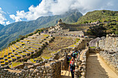 Touristen beim Besuch der Terrassen und Ruinen von Machu Picchu,UNESCO-Weltkulturerbe,Heiliges Tal,Peru,Südamerika