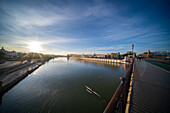 Capture of a serene sunrise over the Guadalquivir River, from the iconic Triana Bridge. The peaceful morning atmosphere reflects on the water alongside Betis Street.