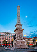 The obelisk stands tall at Praca dos Restauradores as dusk settles over Lisbon, showcasing the city's charm and historic landmarks.