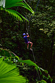 Young caucasian woman canyoning and rappelling in Costa Rica