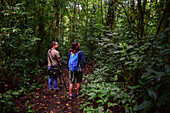 George of the Cloud Forest, guide and specialist, guides a young woman through Monterey cloud forest during fauna tour, Costa Rica