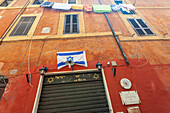 Rome, Italy, July 2017, The vibrant Jewish flag hangs prominently in the Roman ghetto, showcasing cultural heritage in a historic setting.