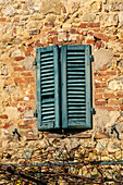 Wooden shutters on a building in the medieval walled town of Monteriggioni, Sienna, Tuscany, Italy.