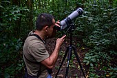 George of the Cloud Forest, guide and specialist, using a spotting scope in Monterey cloud forest during fauna tour, Costa Rica