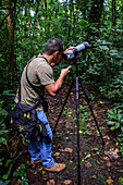 George of the Cloud Forest, guide and specialist, using a spotting scope in Monterey cloud forest during fauna tour, Costa Rica