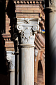 Close up view of ornate columns showcasing intricate details at the stunning Plaza de España in Seville, Spain, highlighting the elegance and craftsmanship of Spanish architecture.