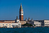 The bell tower & domes of the Basilica of St. Mark behind the Dogana da Mar statue in Venice, Italy.