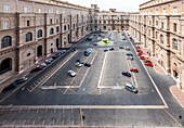 Rome, Italy, July 22 2017, Visitors admire the grand architecture of Belvedere courtyard while vehicles are parked around the central fountain in Vatican City.