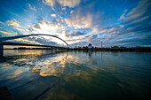 Barqueta Bridge reflecting on river water at Cartuja Island during Sevilla sunset.