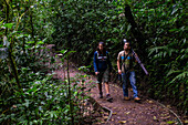 George of the Cloud Forest, guide and specialist, guides a young woman through Monterey cloud forest during fauna tour, Costa Rica