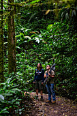 George of the Cloud Forest, guide and specialist, guides a young woman through Monterey cloud forest during fauna tour, Costa Rica