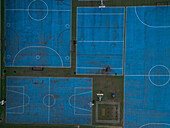 Aerial view of blue basketball and sports courts in school playground