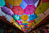 Eine der bunten Straßen in der Kolonialstadt Guatape in Kolumbien,mit bunten Regenschirmen