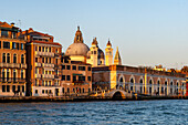 Rear aspect of the Basilica of Santa Maria della Salute from the Giudecca Canal in Venice, Italy with sunset light. St. Mark's campanile or bell tower is just visible behind.