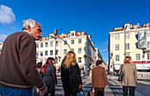 Lisbon, Portugal, March 1 2007, Pedestrians navigate the busy zebra crossing at Rossio Square, Lisbon, with doves flying overhead under the clear blue sky.