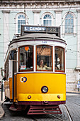 Lisbon, Portugal, March 1 2007, A charming yellow tram navigates the historic streets of Luis de Camoes square in Lisbon, capturing the city's lively atmosphere.