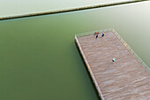 Aerial view of people the wooden dock of an artificial lake