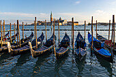 Gondolas moored and covered. Across the Giudecca Canal is the San Giorgio Maggiore Church in Venice, Italy.