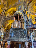 An unusual two-level pulpit of carved stone, supported by eight pillars in St. Mark's Basilica in Venice, Italy.