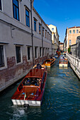 A motorboat water taxis in a canal in Venice, Italy.