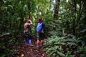 George of the Cloud Forest, guide and specialist, guides a young woman through Monterey cloud forest during fauna tour, Costa Rica