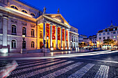 Lisbon, Portugal, March 1 2007, The National Theater in Lisbon illuminated at night, with light trails from passing vehicles and a vibrant city atmosphere.