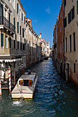 A motorboat water taxi in a canal in Venice, Italy.