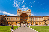 Rome, Italy, July 22 2017, Visitors stroll through the Courtyard of the Pigna, admiring its stunning architecture and lush surroundings under a clear sky in Rome.