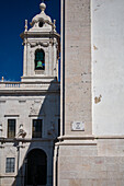 Explore the stunning architecture of Igreja da Graça, a landmark in Lisbon featuring a prominent belfry against a clear blue sky.