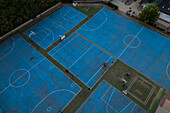 Aerial view of blue basketball and sports courts in school playground