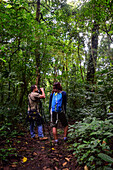 George of the Cloud Forest, guide and specialist, guides a young woman through Monterey cloud forest during fauna tour, Costa Rica