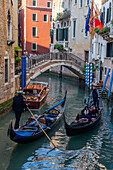 Zwei Gondeln mit Touristen fahren in einem Kanal in der Nähe der Ponte dei Remedio-Brücke in Venedig,Italien.