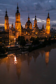 Aerial view of an illuminated El Pilar Basilica Cathedral and the Ebro River at night, Zaragoza, Spain