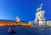 People gather at Praça do Comércio in Lisbon at dusk, showcasing the stunning architecture and the iconic Dom José I statue.