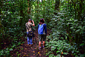 George of the Cloud Forest, guide and specialist, guides a young woman through Monterey cloud forest during fauna tour, Costa Rica