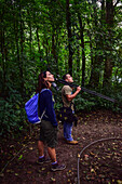 George of the Cloud Forest, guide and specialist, guides a young woman through Monterey cloud forest during fauna tour, Costa Rica