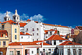 Discover the stunning rooftops of Alfama, featuring the twin towers of Sao Miguel church against a bright Lisbon sky.