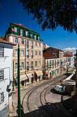 Lisbon, Portugal, March 1 2007, Explore the vibrant streets of Alfama, where historic buildings line Escolas Gerais street under a clear blue sky.