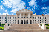 Sao Bento Palace, home of the Portuguese parliament, stands proudly in Lisbon's vibrant urban landscape under a partly cloudy sky.