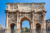 The Arch of Constantine stands prominently with the Colosseum behind it under a clear sky in Rome.