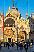 Goldenes Licht bei Sonnenuntergang auf der Westfassade des Markusdoms in Venedig,Italien.