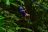 Young caucasian woman canyoning and rappelling in Costa Rica